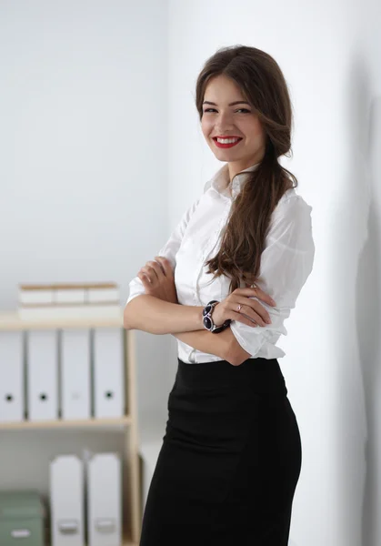 Attractive businesswoman with her arms crossed  standing in office — Stock Photo, Image