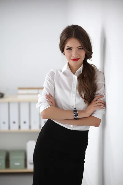 Attractive businesswoman with her arms crossed  standing in office — Stock Photo, Image