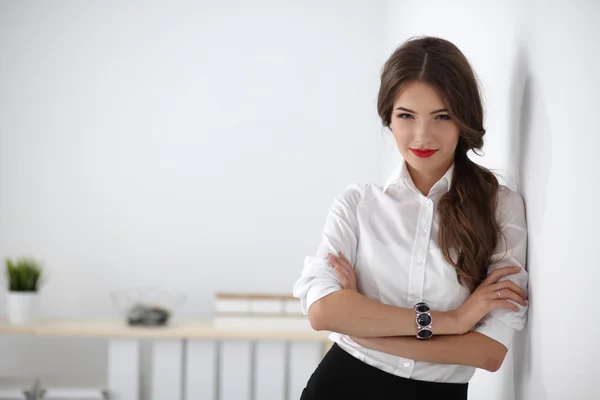 Attractive businesswoman with her arms crossed  standing in office — Stock Photo, Image