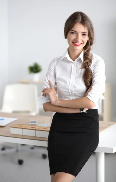 Atractiva mujer de negocios con los brazos cruzados de pie en el cargo — Foto de Stock