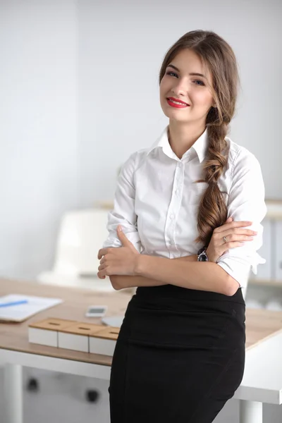 Attractive businesswoman with her arms crossed  standing in office — Stock Photo, Image