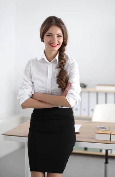Atrakcyjna bizneswoman z skrzyżowanymi ramionami stojąca na stanowisku — Zdjęcie stockowe