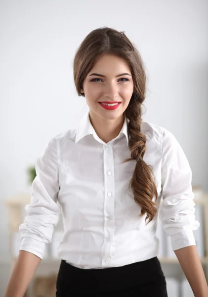 Aantrekkelijke jonge zakenvrouw permanent in de buurt van balie in kantoor — Stockfoto