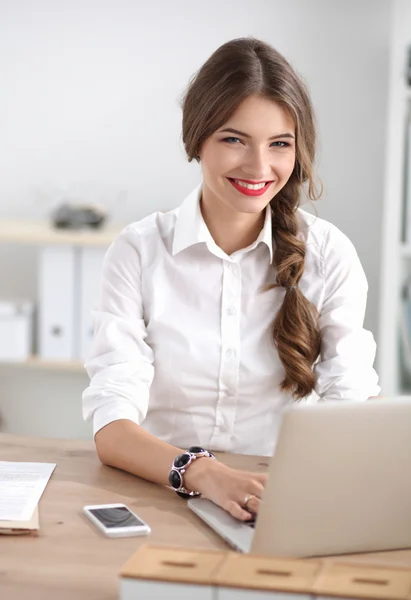 Empresária atraente sentada na mesa no escritório — Fotografia de Stock