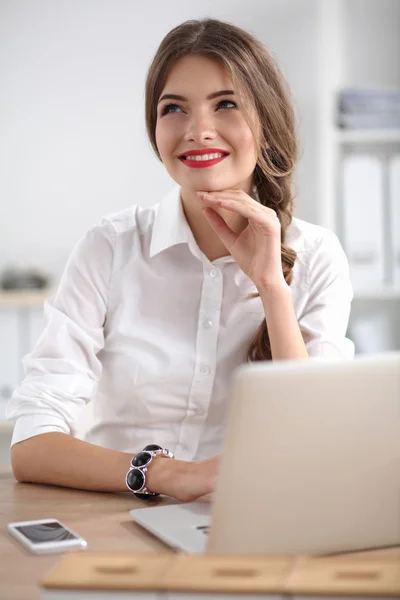 Aantrekkelijke zakenvrouw zit op het bureau in het kantoor — Stockfoto