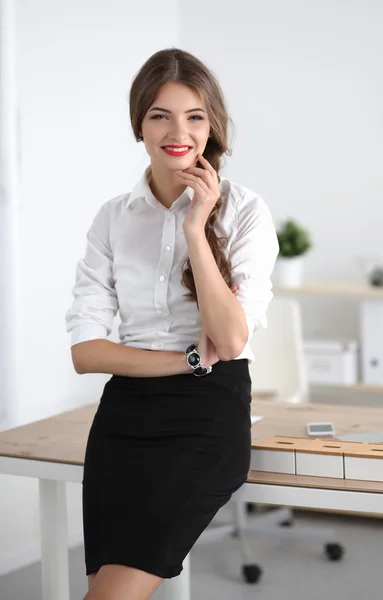 Atractiva mujer de negocios con los brazos cruzados de pie en el cargo —  Fotos de Stock