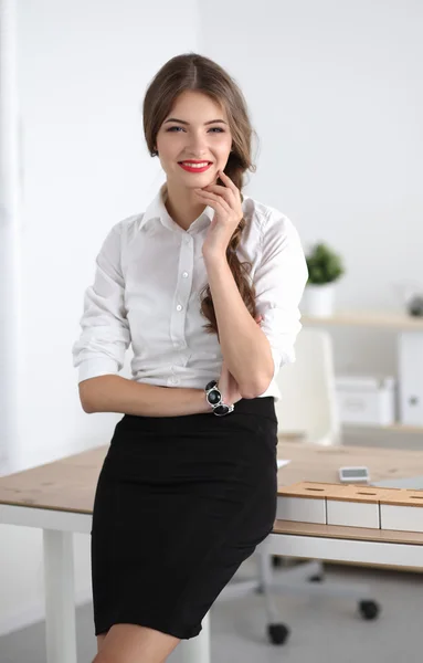 Attractive businesswoman with her arms crossed  standing in office — Stock Photo, Image