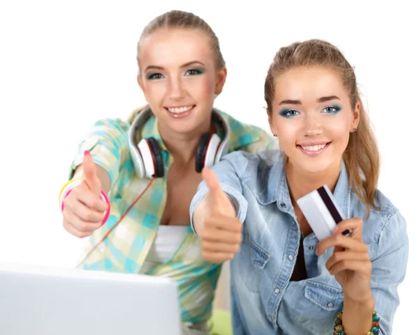 Two young women sitting with laptop  and credit cart showing ok — Stock Photo, Image