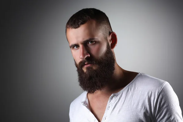 Retrato de homem barbudo bonito em pé, isolado sobre fundo cinza — Fotografia de Stock