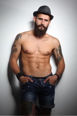 şapka ayakta, gri arka plan üzerinde izole yakışıklı sakallı adam portresi