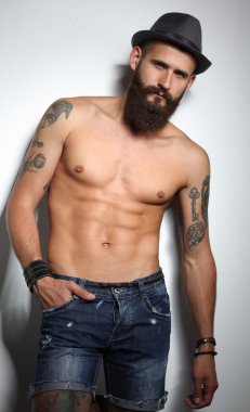 şapka ayakta, gri arka plan üzerinde izole yakışıklı sakallı adam portresi