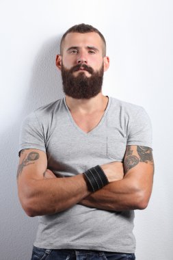 gri arka plan üzerinde izole çapraz kollu yakışıklı sakallı adam portresi