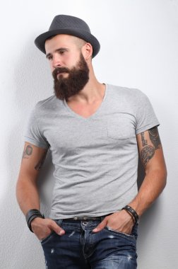 şapka ayakta, gri arka plan üzerinde izole yakışıklı sakallı adam portresi