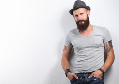 şapka ayakta, gri arka plan üzerinde izole yakışıklı sakallı adam portresi