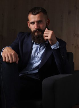 koyu arka plan üzerinde izole sofa ofis lobisinde oturan işadamı