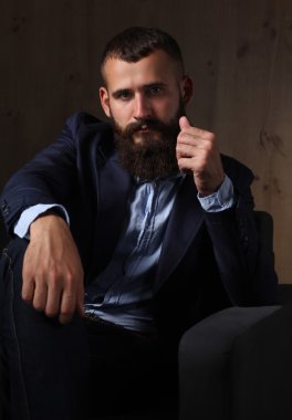 koyu arka plan üzerinde izole sofa ofis lobisinde oturan işadamı