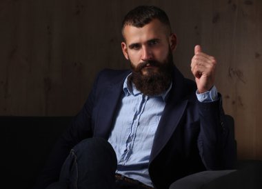 koyu arka plan üzerinde izole sofa ofis lobisinde oturan işadamı