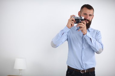 Genç sakallı adam sana beyaz arka plan ayakta iken onun kamera ile odaklama