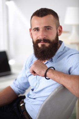 Genç işadamı koltukta oturuyor.