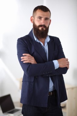 yakışıklı genç işadamı duran kolları ile ofiste geçti