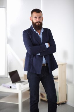 yakışıklı genç işadamı duran kolları ile ofiste geçti