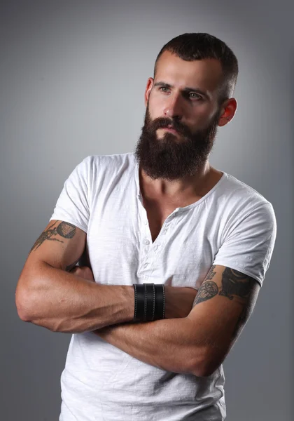 Portrait of handsome bearded man standing with crossed arms, isolated on grey background — Stock Photo, Image
