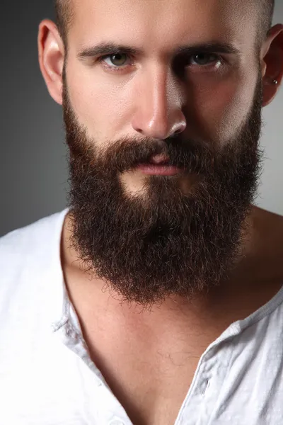 Szép szakállas férfi állandó, elszigetelt szürke háttér portréja — Stock Fotó