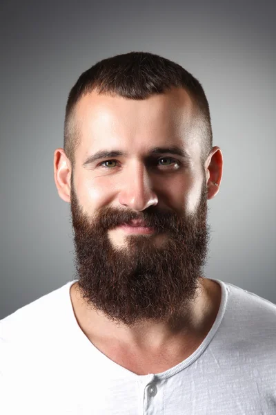 Retrato de homem barbudo bonito em pé, isolado sobre fundo cinza — Fotografia de Stock