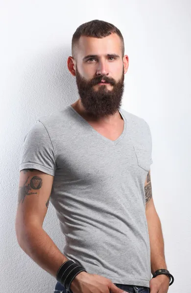 ayakta, gri arka plan üzerinde izole yakışıklı sakallı adam portresi