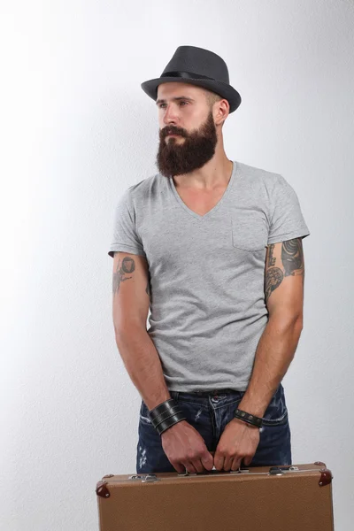 Kötü ile duran şapkalı yakışıklı sakallı adam portresi izole beyaz zemin üzerine — Stok fotoğraf
