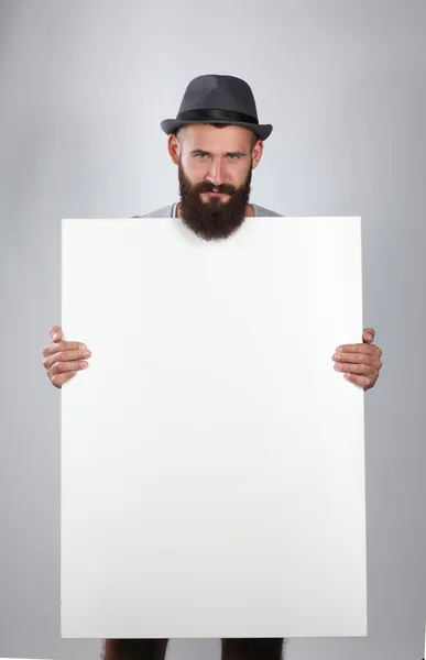 Retrato de un joven con sombrero sosteniendo un blanco, aislado sobre fondo blanco —  Fotos de Stock