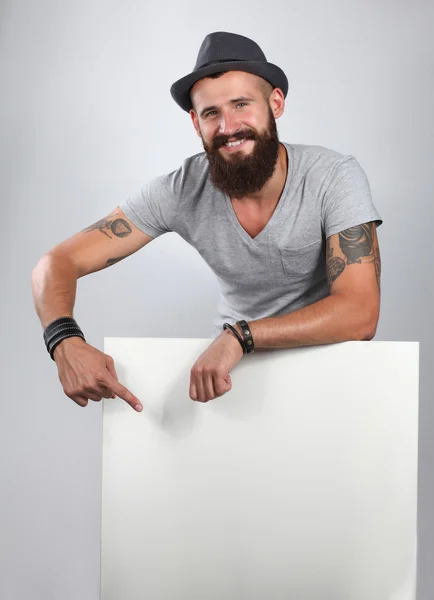 Retrato de un joven con sombrero de pie cerca del blanco, aislado sobre fondo blanco — Foto de Stock