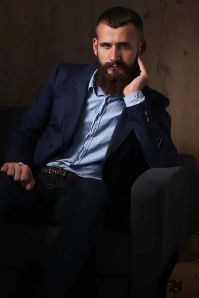 Geschäftsmann auf dem Sofa in der Büro-Lobby, isoliert auf dunklem Hintergrund — Stockfoto