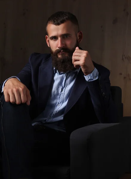 Empresário sentado no sofá no lobby do escritório, isolado no fundo escuro — Fotografia de Stock