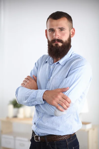 Retrato de un hombre de negocios con las manos dobladas de pie en la oficina —  Fotos de Stock