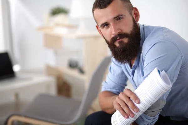 Jonge zakenman zittend op een stoel met boek in office — Stockfoto