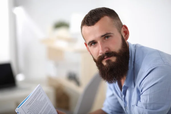 Jonge zakenman zit op stoel in functie — Stockfoto