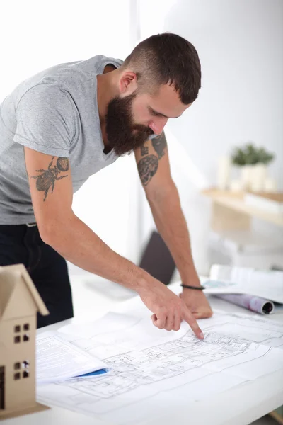 Portrait of male architect with blueprints at desk in office — Stock Photo, Image