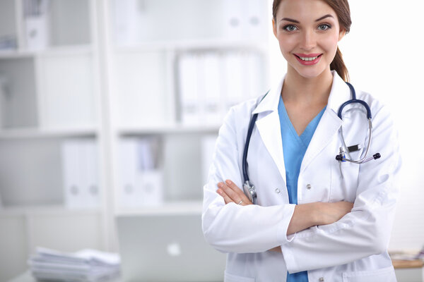 Portrait of young woman doctor with white coat standing in hospital