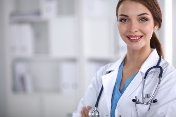 Portrait of young woman doctor with white coat standing in hospital