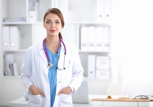 Portrait of young woman doctor with white coat standing in hospital — Stock Photo, Image