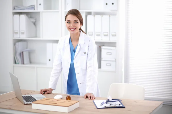 Young doctor woman standing near table in hospital — Stock Photo, Image