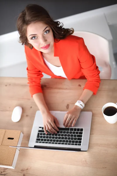 Attraktive Frau sitzt im Büro am Schreibtisch und arbeitet mit Laptop — Stockfoto