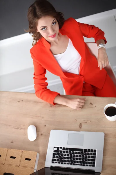 Attraktive Frau sitzt im Büro am Schreibtisch und arbeitet mit Laptop — Stockfoto