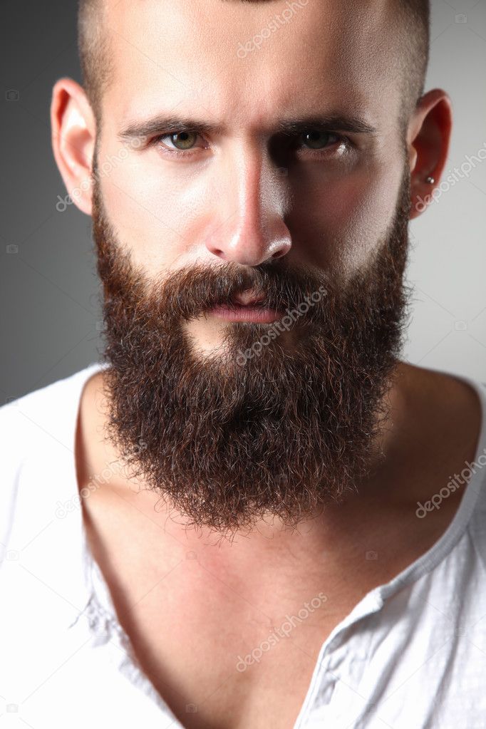 Portrait of handsome bearded man standing, isolated on grey background