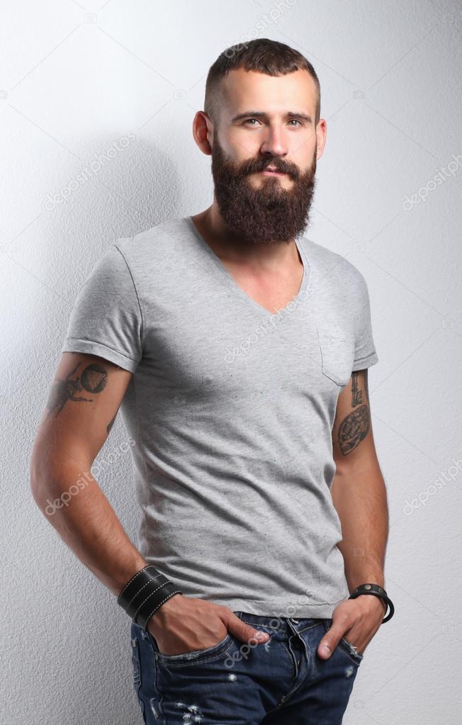 Portrait of handsome bearded man standing, isolated on grey background