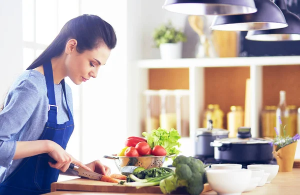 Mujer joven cortando verduras en la cocina en casa — Foto de Stock