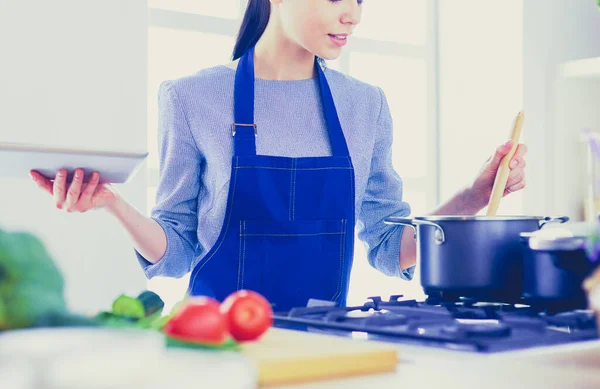 Mujer joven usando una tableta para cocinar en su cocina —  Fotos de Stock