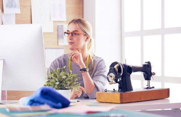 красивая молодая девушка на фабрике с швейной машинкой за столом