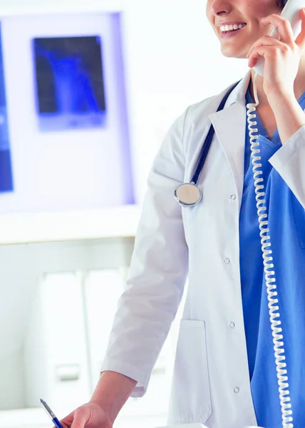 Serieuze dokter aan de telefoon in haar kantoor — Stockfoto